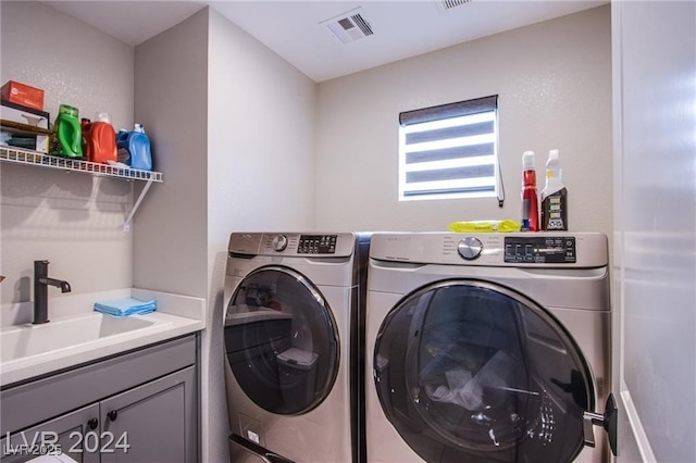 clothes washing area with cabinets, independent washer and dryer, and sink