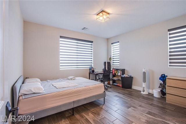 bedroom with dark hardwood / wood-style flooring