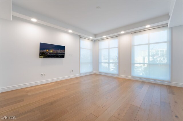 spare room featuring recessed lighting, light wood-style flooring, and baseboards