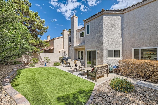 back of house featuring a patio area, outdoor lounge area, and a lawn