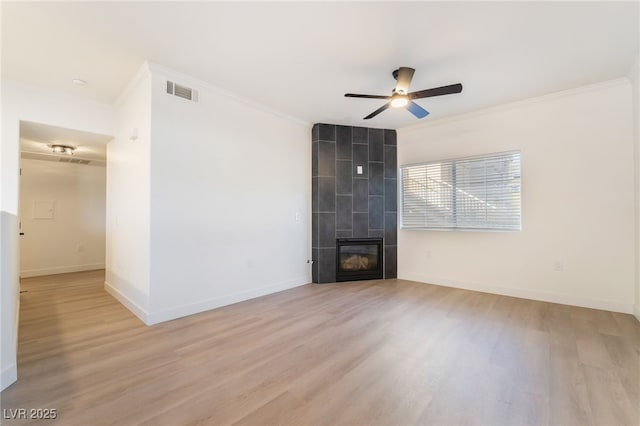 unfurnished living room featuring a fireplace, light hardwood / wood-style flooring, crown molding, and ceiling fan