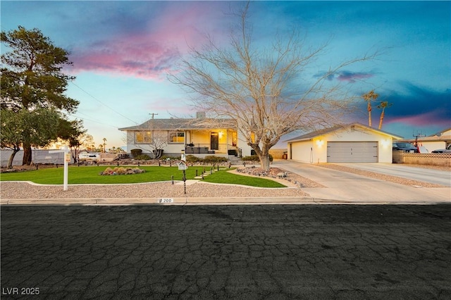 single story home with concrete driveway, a yard, and an attached garage