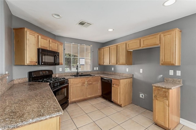 kitchen featuring black appliances, sink, light stone counters, light brown cabinetry, and light tile patterned flooring