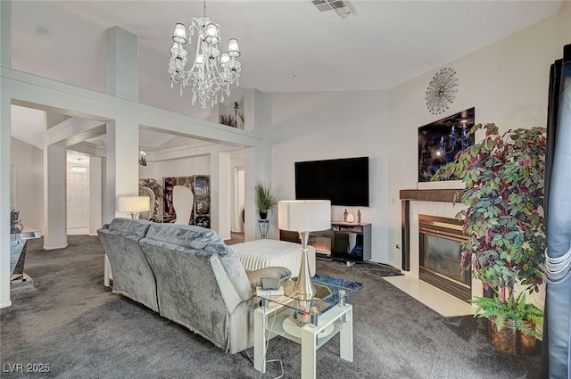 living room featuring carpet floors, a tile fireplace, visible vents, and a notable chandelier