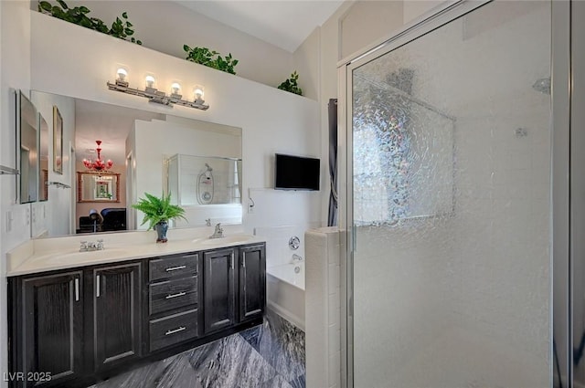 full bathroom with a garden tub, double vanity, a sink, and a shower stall