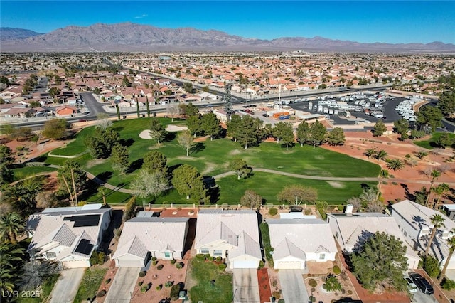 drone / aerial view with view of golf course, a residential view, and a mountain view