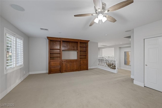 unfurnished living room with visible vents, light carpet, and baseboards