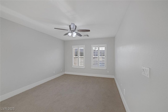 spare room with a ceiling fan, visible vents, carpet floors, and baseboards