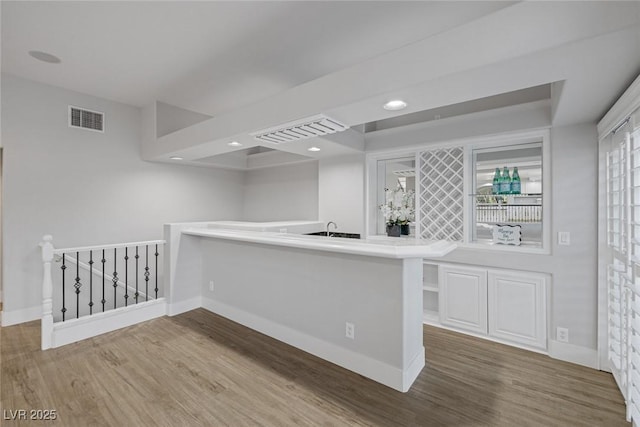 interior space featuring baseboards, visible vents, wood finished floors, and recessed lighting