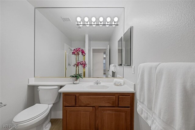 bathroom featuring visible vents, vanity, toilet, and wood finished floors