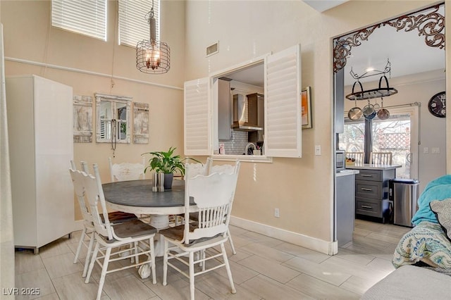 dining area with a high ceiling and a notable chandelier