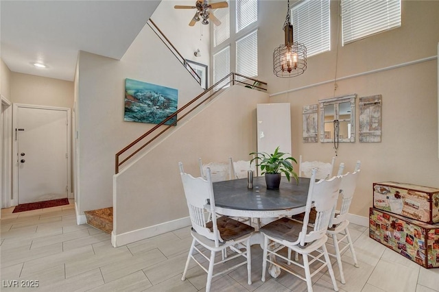 dining space with ceiling fan and a high ceiling