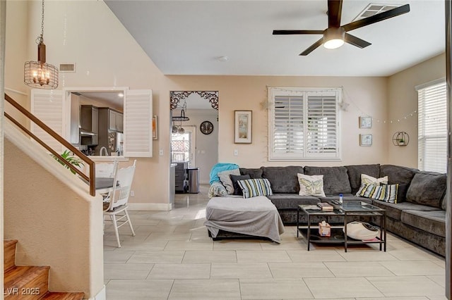 living room with ceiling fan with notable chandelier