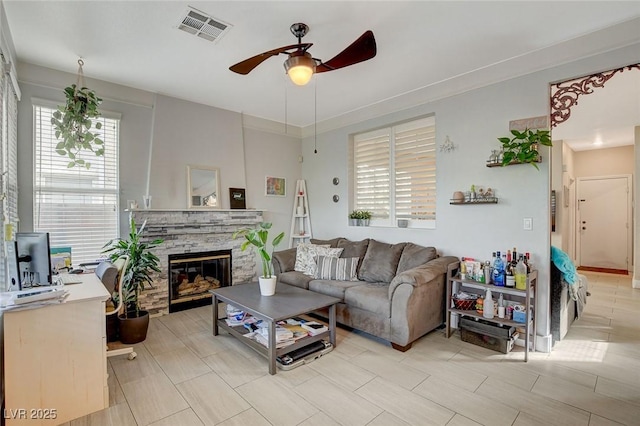 living room with a fireplace and ceiling fan