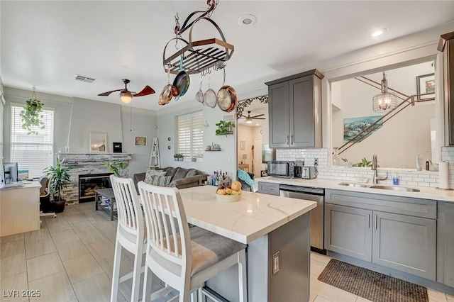 kitchen featuring ceiling fan, sink, dishwasher, and a kitchen island