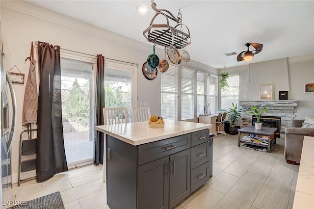 kitchen featuring a fireplace, a center island, and light tile patterned floors