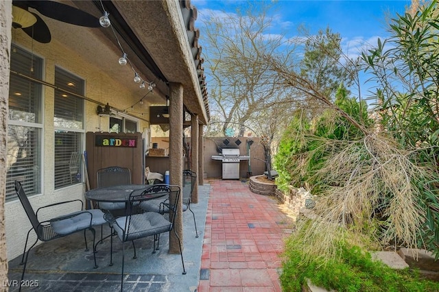 view of patio with ceiling fan and a grill