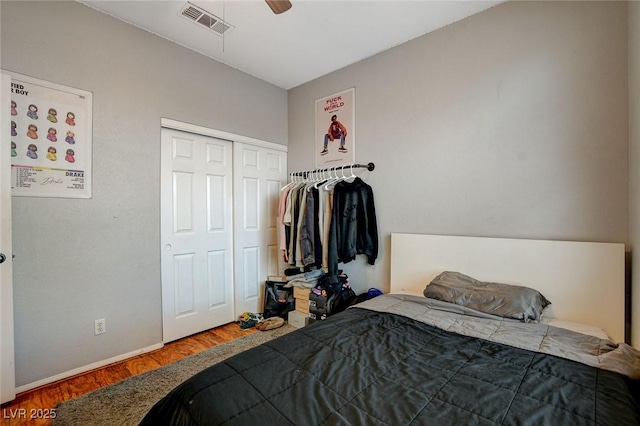 bedroom with ceiling fan, wood-type flooring, and a closet