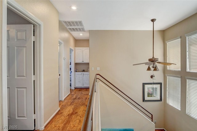 corridor with a wealth of natural light and light hardwood / wood-style floors