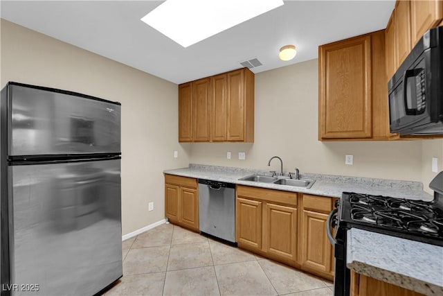 kitchen with light tile patterned floors, sink, and black appliances