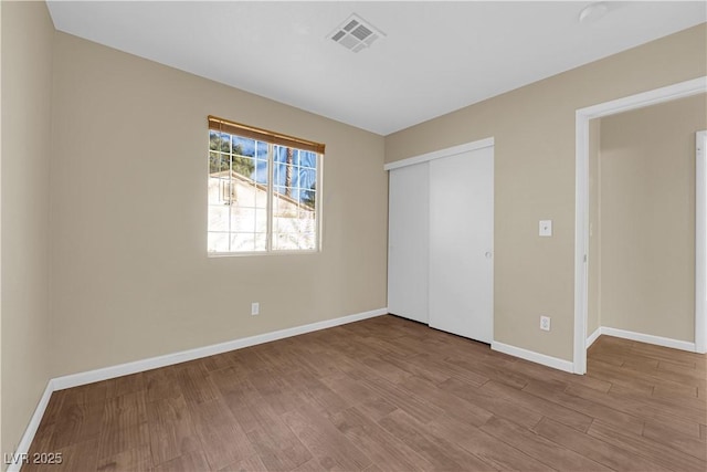 unfurnished bedroom with light wood-type flooring and a closet