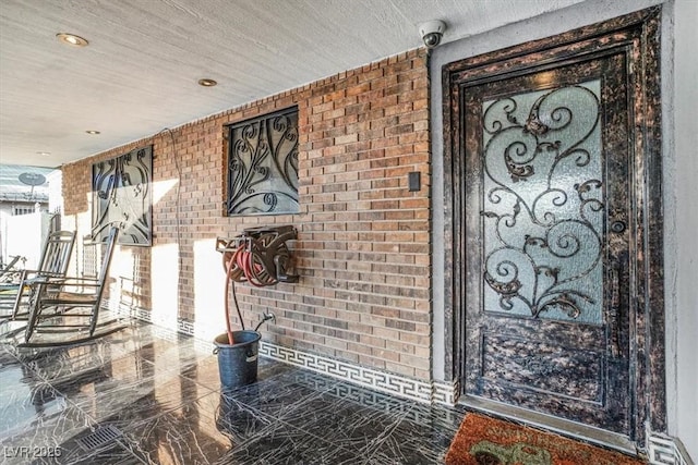 interior space featuring marble finish floor and brick wall