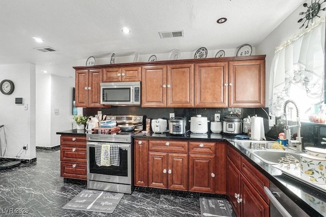 kitchen featuring stainless steel appliances, a sink, visible vents, marble finish floor, and dark countertops