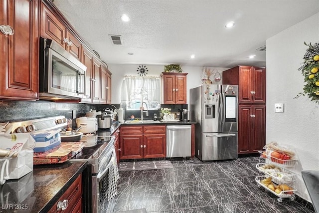 kitchen featuring marble finish floor, stainless steel appliances, visible vents, decorative backsplash, and a sink