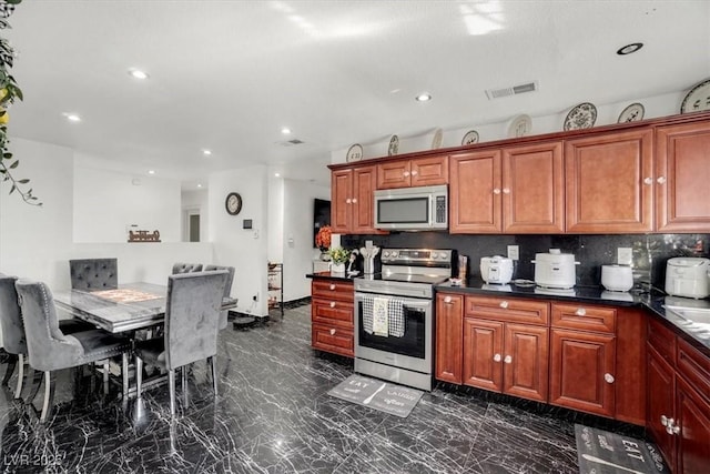 kitchen featuring recessed lighting, stainless steel appliances, visible vents, marble finish floor, and dark countertops