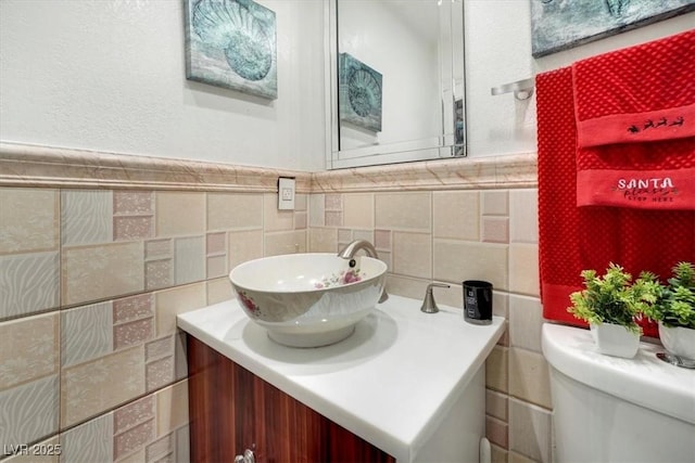 half bathroom with toilet, vanity, and tile walls