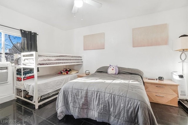 bedroom with dark tile patterned floors and ceiling fan