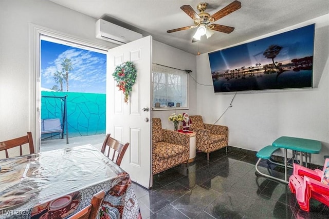 living area with a wall mounted air conditioner, granite finish floor, a ceiling fan, and baseboards