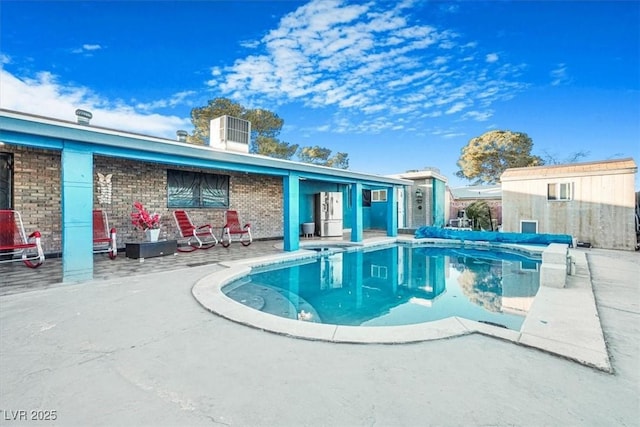 view of pool featuring a patio area, a covered pool, and an outdoor structure