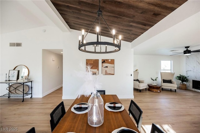 dining area with ceiling fan with notable chandelier, light hardwood / wood-style floors, lofted ceiling, and wood ceiling