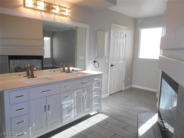 bathroom with a multi sided fireplace and vanity