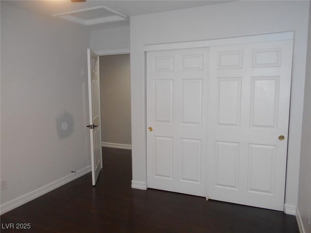 unfurnished bedroom with dark wood-type flooring and a closet