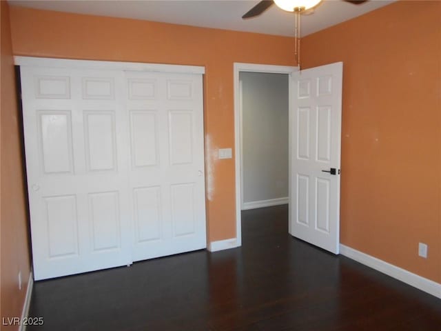 unfurnished bedroom with ceiling fan, a closet, and dark hardwood / wood-style flooring