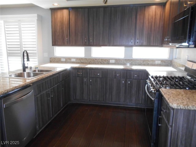 kitchen featuring dark brown cabinetry, black appliances, sink, light stone counters, and dark wood-type flooring