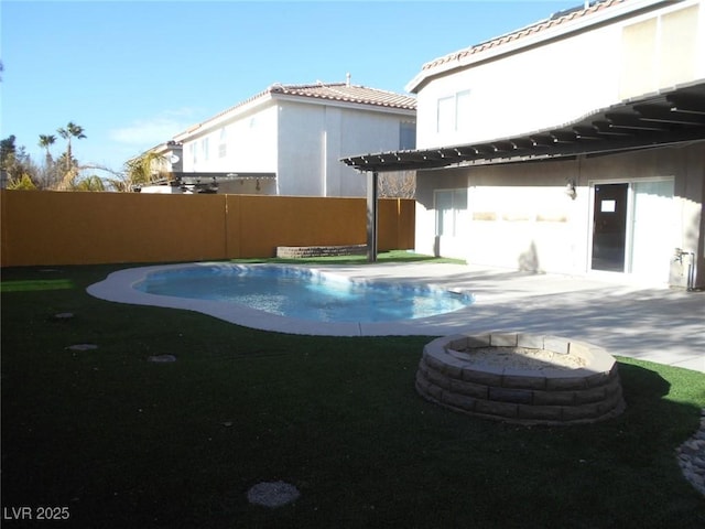 rear view of property with a patio, an outdoor fire pit, and a fenced in pool