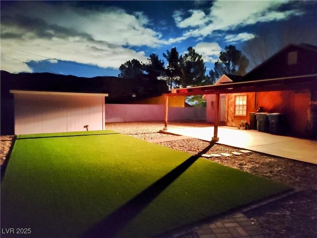 yard at dusk featuring a patio