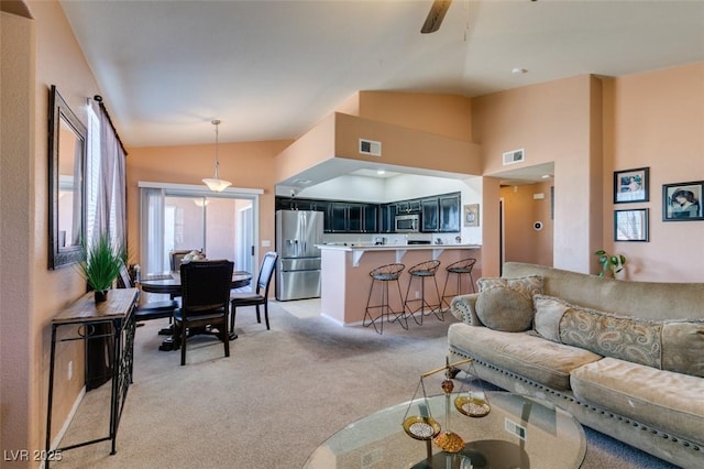 living area featuring light carpet, visible vents, and lofted ceiling