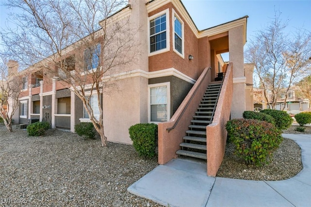 view of side of property with stairs and stucco siding