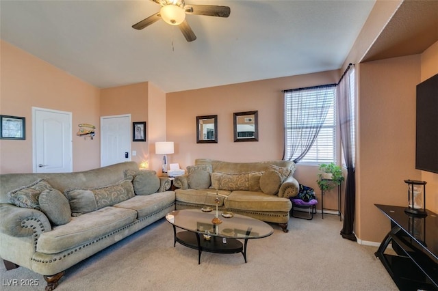 living room with a ceiling fan, light carpet, and baseboards