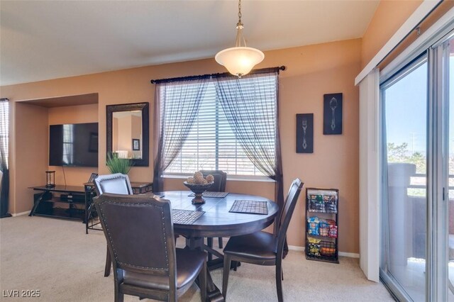 dining room featuring light carpet and baseboards