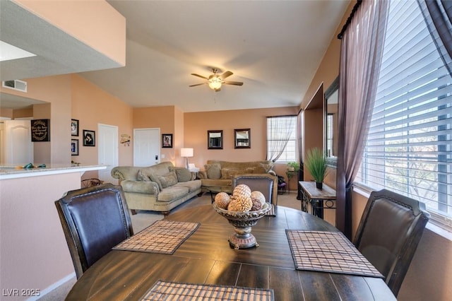 dining room featuring ceiling fan, visible vents, and vaulted ceiling