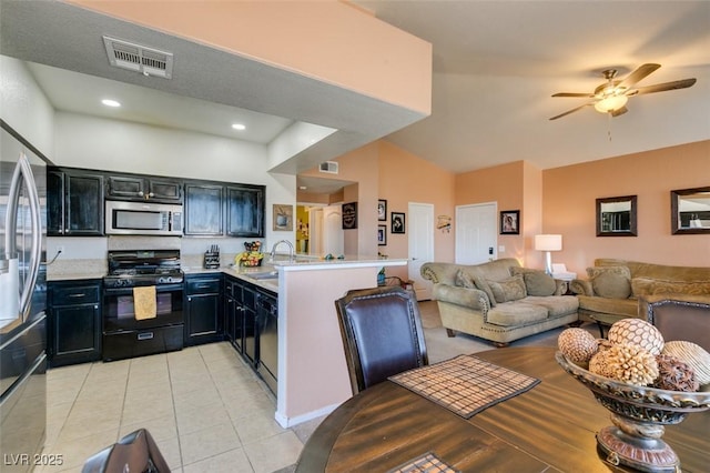 kitchen with visible vents, open floor plan, dark cabinets, a peninsula, and black appliances