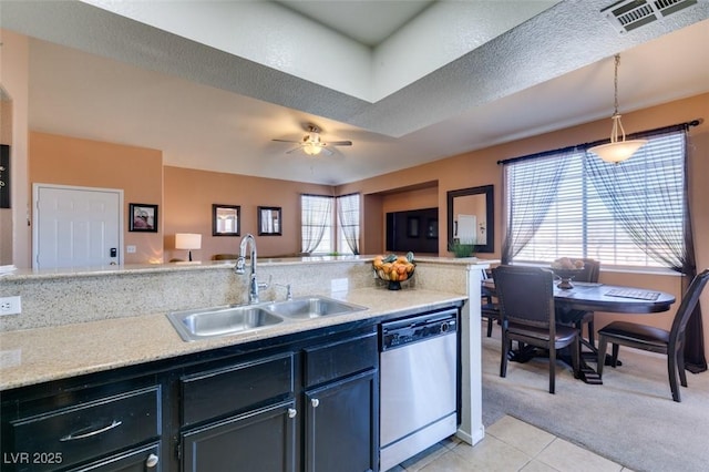 kitchen with visible vents, light countertops, hanging light fixtures, stainless steel dishwasher, and a sink