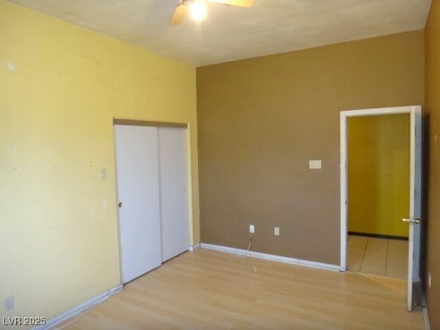 unfurnished bedroom featuring wood finished floors, a ceiling fan, and baseboards