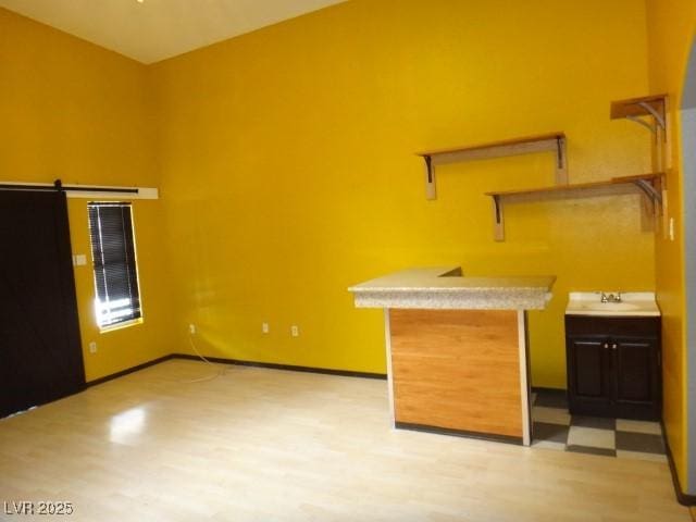 interior space with a barn door, baseboards, and light countertops