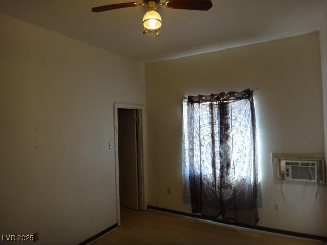 unfurnished room featuring a wall mounted air conditioner and a ceiling fan